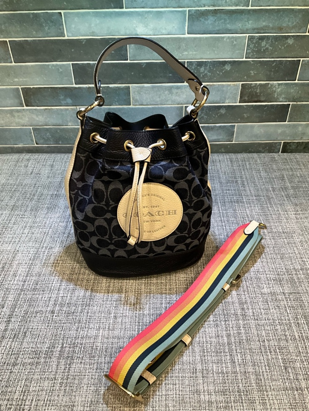 Coach Dempsey Navy Signature Bucket Bag with Tan Accents and Rainbow Strap